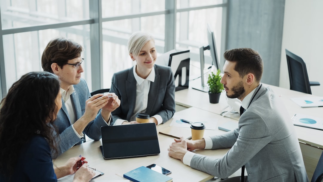 Four investing professionals in a meeting around a table.