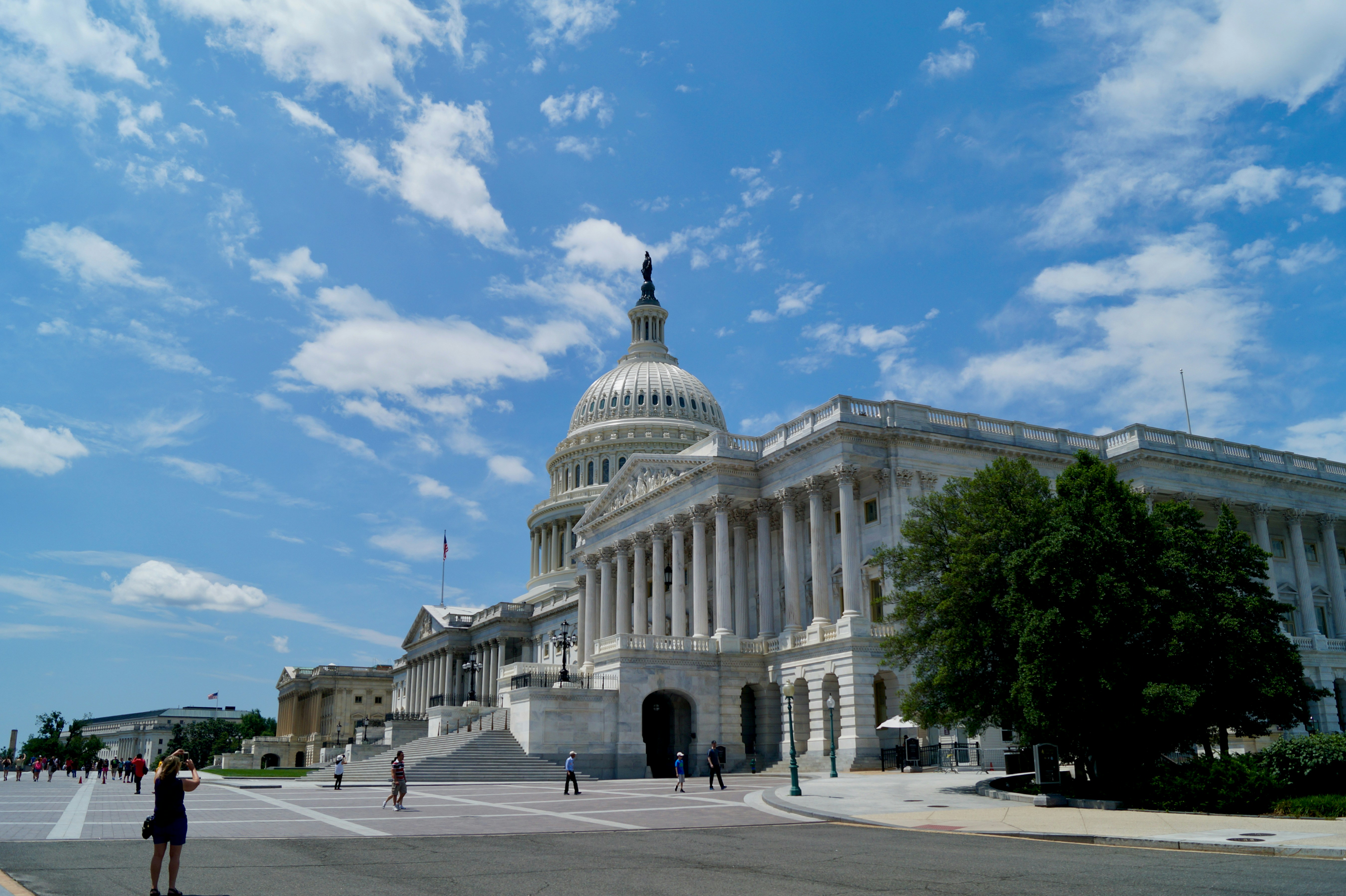 The US Capitol building in Washington D.C. with a blue sky and clouds.